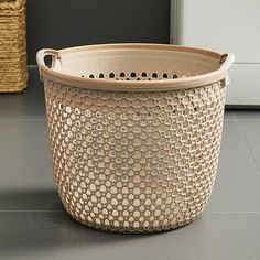 a basket sitting on top of a floor next to a wall with a door in the background