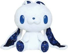 a white stuffed animal with blue eyes and stars on it's tail, sitting in front of a white background