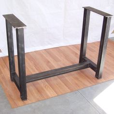 two metal stands sitting on top of a hard wood floor next to a white wall