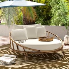 an outdoor seating area with white cushions and umbrella