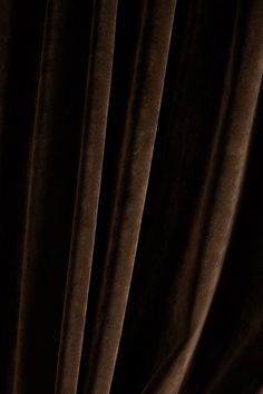 a close up view of a curtain with dark brown velvet drapes on the side