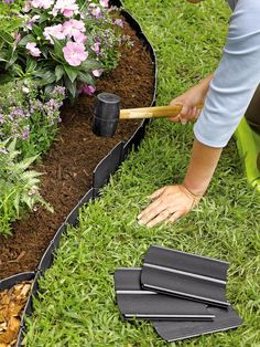 a person is digging in the grass with a shovel and some gardening implements next to them