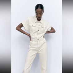 Long Jumpsuit With Lapel Collar And Turned Up Sleeves. Front Patch Pockets With Buttoned Flap At Chest And Back Patch Pocket. Straight Leg. Front Metal Button Closure. Outer Shell 100 % White Cotton Denim Jumpsuit For Summer, Cream Jumpsuits And Rompers With Pockets For Summer, Summer White Cotton Denim Jumpsuit, Chic Zara Jumpsuits And Rompers With Pockets, Trendy White Cotton Denim Jumpsuit, Trendy White Denim Jumpsuit With Pockets, Trendy Beige Jumpsuits And Rompers For Spring, Fitted White Cotton Denim Jumpsuit, White Fitted Cotton Denim Jumpsuit