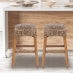 two wooden stools sitting in front of a counter