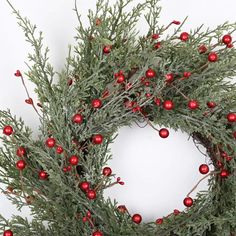 a christmas wreath with red balls and greenery