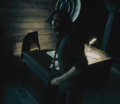 a man standing next to a table with a clock on it