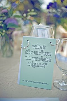 two wine glasses sitting on top of a table next to a sign that says what should we do on date nights?