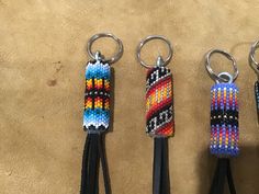 three keychains with different colors and designs are on the floor next to each other