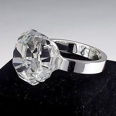 a diamond ring sitting on top of a black surface