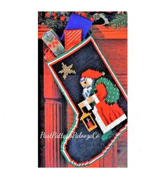 a cross stitch christmas stocking hanging on a door with an image of a woman