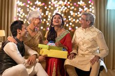 a group of people sitting around each other holding a box with a gift in it