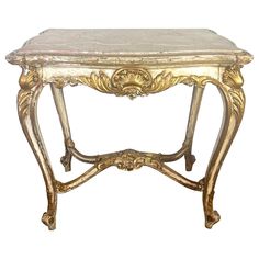 an antique console table with marble top and gold leaf decoration on the legs, isolated against a white background