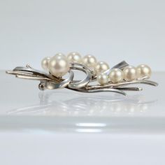 A very fine vintage Mikimoto Akoya cultured pearl and sterling silver brooch or pin.  With graduated round white pearls set on sterling silver bouquet-like stems.  Simply a fine brooch from the legendary Mikimoto!  Date: 20th Century  Overall Condition: It is in overall good, as-pictured, used estate condition with some very fine & light surface scratches and other signs of expected light wear consistent with age.  Fineness: Unmarked for fineness.  Marks: S M  Measurements: Height: ca. 52 mm Wid Silver Bouquet, Sterling Silver Brooch, Pearl Set, Silver Brooch, Best Wear, Cultured Pearls, Vintage Brooches, Pearl White, 20th Century