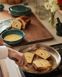 a person cooking food in a pan on the stove