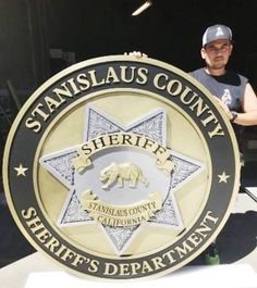 a man standing next to a sign that says, stanisjaus county sheriff's department