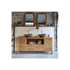 two bowls sit on top of a wooden table in front of a brick wall with mirrors above it