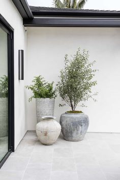 two large vases sitting next to each other on a patio