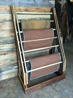 two brown leather seats sitting on top of a wooden stand next to a coat rack