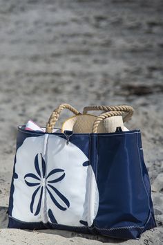 a blue and white bag sitting on top of a sandy beach