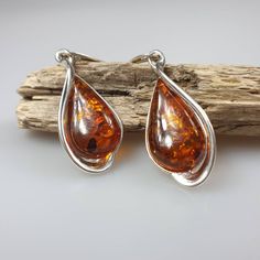 Gemstone Earrings. Sterling silver 925 earrings with genuine Baltic Amber gremstone and all hallmarks. Length: 5 cm. One pair included. Each pair has a different shade of brown colour. The same model is also available in green Amber colour.: https://www.etsy.com/listing/1064943153/green-amber-earrings-sterling-silver-925?ref=listings_manager_grid This item was made of natural Baltic Amber. All the amber used in my jewelry is collected in my home country Lithuania. I sell only genuine, real, not