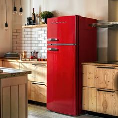 a red refrigerator freezer sitting inside of a kitchen