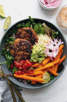 a bowl filled with meat, veggies and coleslaw on top of a table