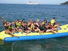 a group of people riding on top of an inflatable raft across the ocean