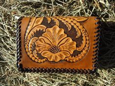 a leather wallet sitting on top of some grass