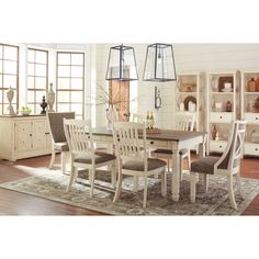 a dining room table with chairs and a rug