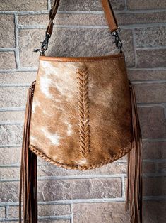 This shoulder bag is upcycled from cowhide. It has many inner compartments which makes it spacious. The combination of white and brown hairon along with the fringes gives it a very attractive look. Cowhide will vary. No two bags will be the same. You may or may not receive the image example shown. Item Width 12 Item Depth 2 Item Height 10 Shoulder 22