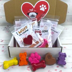 a box filled with lots of different types of dog treats and candies on top of a table