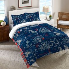 a bed room with a neatly made bed and an ocean scene on the comforter