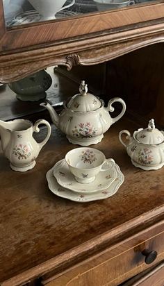 an old dresser with china on it and a mirror in the back ground that has been turned into a tea set