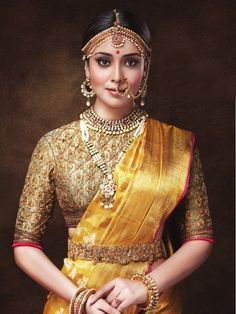 a woman in a yellow sari with gold jewelry