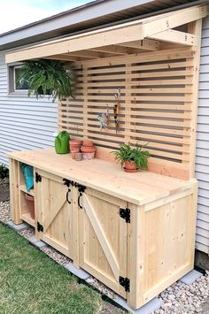 a wooden bench with potted plants on it in front of a white house,