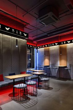 an empty restaurant with tables and chairs in the center, lit up by red lights