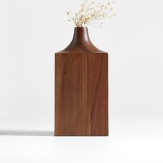 a wooden vase with flowers in it on a white background, that appears to be made out of wood