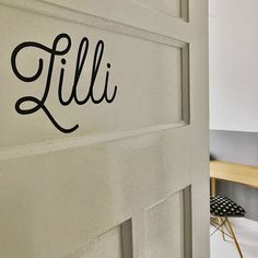 the name lili is written on the wall next to a table and chair in front of it