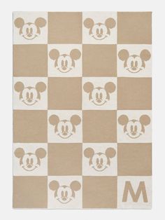 the mickey mouse rug is on display in front of a white and brown checkerboard background