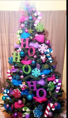 a brightly colored christmas tree decorated with colorful ornaments and letters that spell out ho hoo