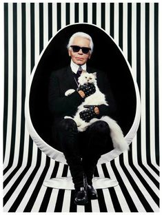 a man in a suit and sunglasses holding a white dog on the cover of gq magazine