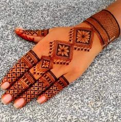 a woman's hand with henna tattoos on it