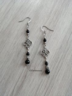 Earrings made of onyx.Black onyx is a stone of protection, it protects from the evil eye, it repels the presence of spirits who would try to influence you, it is very useful for mediums. It promotes a sense of responsibility and helps to maintain self-control by being more composed.Dimensions: 7 centimeters in length (with the hook)Materials used: the ear hooks are made of stainless steel, the other metal parts are made of zinc alloy, lonyx (each natural stone being unique, they cannot be identi Vintage Black Dangle Jewelry, Handmade Silver Witchy Earrings, Gothic Onyx Jewelry For Gift, Black Gothic Pierced Earrings, Adjustable Gothic Onyx Jewelry, Black Victorian Dangle Jewelry, Silver Witchy Pierced Earrings, Handmade Black Gothic Earrings, Black Witchy Jewelry Gift