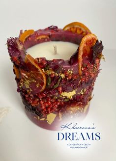 a candle that has some kind of fruit on it with the words dreams written in front of it