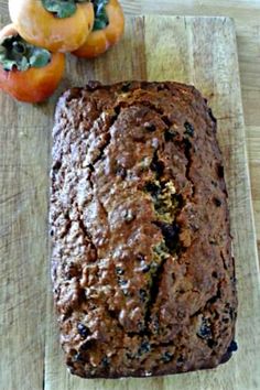 a loaf of bread sitting on top of a wooden cutting board next to two tomatoes