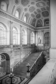 the interior of an old building with ornately decorated walls and stairs, painted in black and white