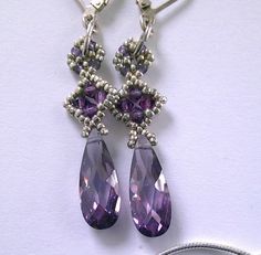 "The talented designer, Marcia DeCoster, named these earrings MEDICI DROP, suggesting that they 'might have adorned the noblewoman of the Renaissance'.   The stunning elongated purple cubic zirconias are faceted to give a diamond-like rainbow effect. This gemstone is actually called a diamond simulant but it's man-made. Smaller Swarovski crystals and tiny silver beads add rich contrast to the earrings. A very striking and impressive addition to any festive occasion.  The sterling silver lever back ear wires are comfortable and secure.   Length:               1.5\" Cubic zirconia:  2cm x 8mm" Elegant Purple Drop Crystal Earrings, Purple Cubic Zirconia Earrings With Sparkling Stones, Elegant Purple Cubic Zirconia Crystal Earrings, Dazzling Sterling Silver Teardrop Crystal Earrings, Dazzling Teardrop Sterling Silver Crystal Earrings, Teardrop Crystal Earrings With Rhinestones For Gift, Teardrop Crystal Earrings With Rhinestones, Faceted Crystal Teardrop Earrings, Elegant Purple Rhinestone Crystal Earrings