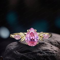 Pear Pink Sapphire Engagement Ring Yellow Gold Promise Ring Leaf Nature Inspired Ring Pink Gemstone Art Deco Ring Handmade Jewelry ForWomen ☛Ring Details ☛ Center stone >> 6*8mm Lab Pink Sapphire Cut: pear cut ☛ side stone side stone:0.12ctw  Lab Pink Sapphire ☛Width:1.5mm ☛Thickness :1.2mm ☛ Production Please allow us 2-3 weeks to make the perfect ring. Rush orders are accepted, please contact me for more details before placing an order. ☛ Shipping Domestic shipping takes 3 to 5 days and intern Pink Pear-shaped Gemstone Jewelry, Pink Teardrop Fine Jewelry Ring, Pink Teardrop Jewelry With Center Stone, Pink Open Ring With Accent Stones Jewelry, Pink Open Ring Jewelry With Accent Stones, Handmade Pink Rings For Anniversary, Pink Pear-shaped Rings For Gift, Pink Teardrop Anniversary Ring, Pink Stone Jewelry For Anniversary