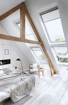 an attic bedroom with white walls and wooden beams on the ceiling, along with large windows