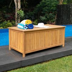 a wooden box with towels on it next to a pool